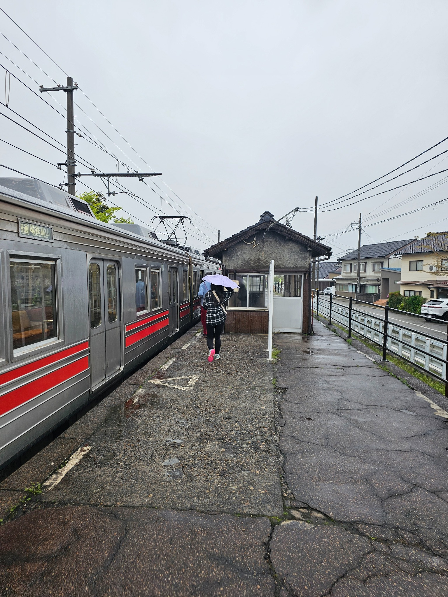 Rainy platform and train at Kamidaki Station.