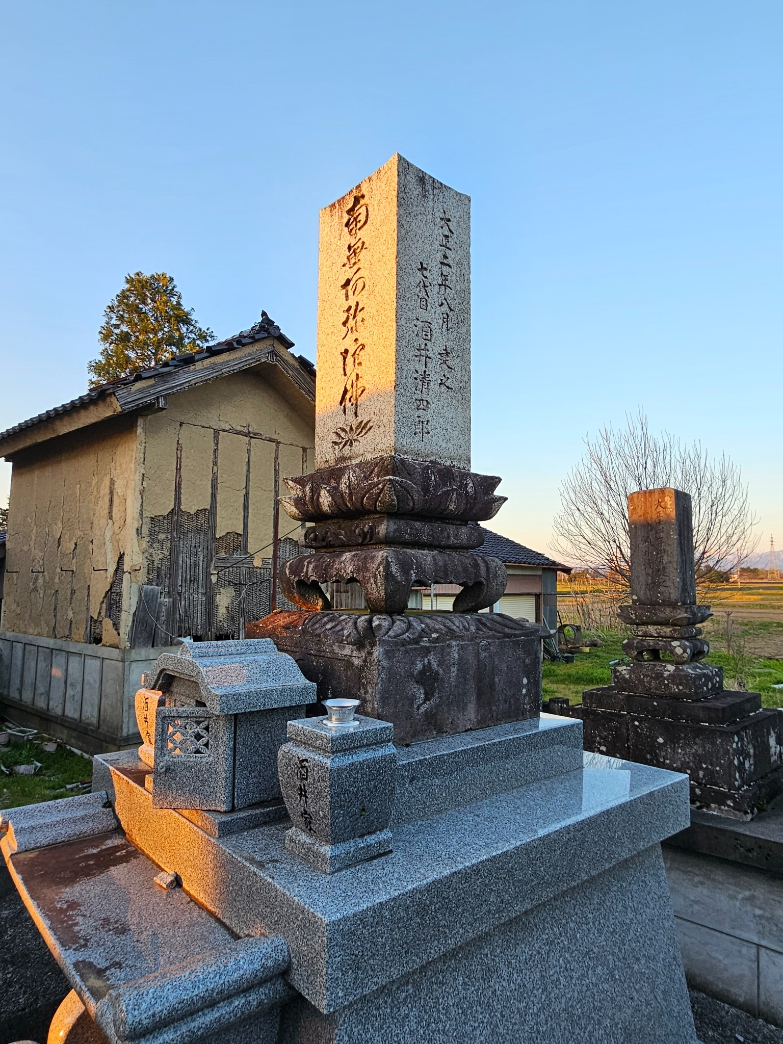 Sakai family grave and kura at sunset.